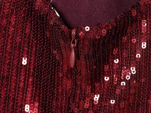 Detail of burgundy sequin dress showing seamless hidden zipper and premium stitching