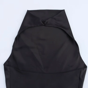 Detail of black halter dress with satin texture featuring twisted knot and cutout detail