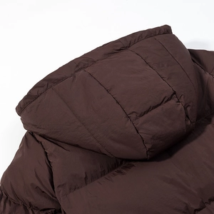 Detailed close-up of hooded shoulder and quilted texture on dark brown padded jacket