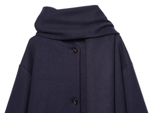 Detail of navy blue wool blend coat with scarf collar and black button closure