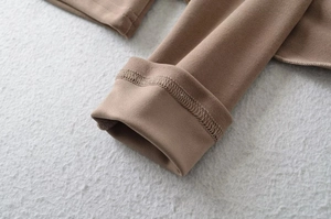 Detailed close-up of the smooth cuff stitching and soft suede texture on a brown T-shirt