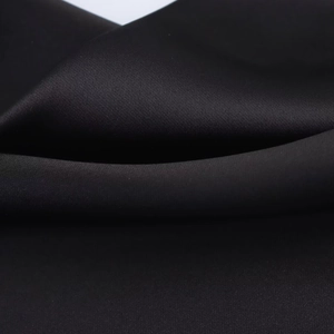 Macro shot of black satin fabric detail with smooth texture and elegant drapes
