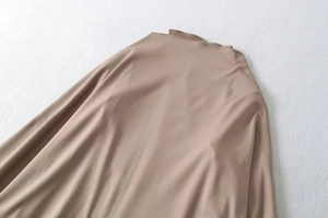 Detail view of the brown velvet top featuring a mock neck and smooth draped fabric texture