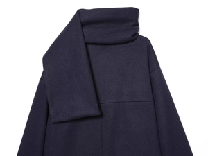 Detail of navy blue wool blend coat showing high neck scarf collar texture and fabric