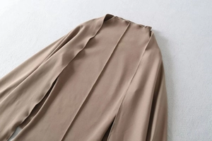 Flat lay of brown cardigan showing fine stitching and minimalist jersey fabric texture