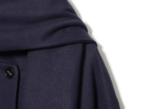 Detail of wool blend coat collar showing dark blue texture and round black button