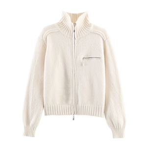 Detailed macro view of the stand collar zipper and ribbed texture on the white knit cardigan