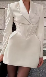 Detail of white blazer dress showing corset-style pleated waist and slim fit silhouette