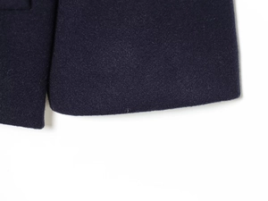 Macro shot of the premium wool blend coat showing high-quality stitching and fabric texture