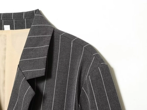 Close-up of the grey pinstripe blazer notched lapel with high-quality twill fabric texture