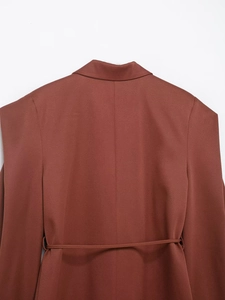 Detailaufnahme des rostbraunen Blazers mit Reverskragen und Gürtel an der Taille