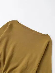 Dettaglio di un elegante maglione in maglia giallo senape con scollo a barca e trama fine