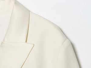 Detail shot of the cream-white blazer dress collar and premium fabric texture