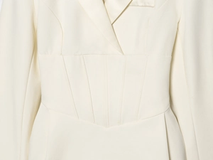 Detail of tailored corset waist design and premium woven texture on ivory blazer dress