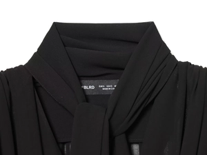 Detail view of the elegant black chiffon shirt featuring a chic neck tie and label