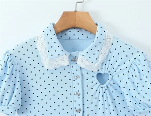 Detail of light blue polka dot rib-knit top with lace collar and heart cut-out