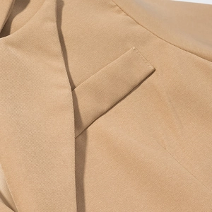 Vue macro de la texture sergé camel et des détails de couture sur le revers d'un manteau