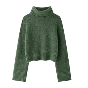 Dettaglio della trama pelosa e dell'orlo a coste del maglione a collo alto verde scuro