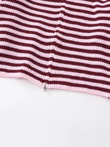 Close-up of pink and burgundy striped knitwear with a stylish silver metal zipper puller