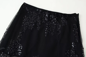 Détail de la broderie florale en paillettes noires sur la jupe midi en maille à taille haute