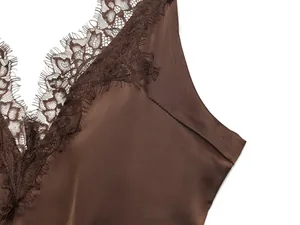 Nahaufnahme eines dunkelbraunen Satin-Slipkleids mit feinem Wimpernspitzenbesatz am Ausschnitt
