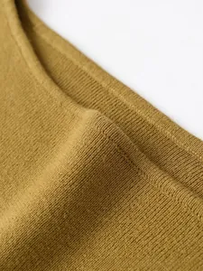 Dettaglio ravvicinato del tessuto a maglia giallo zenzero con trama a coste fini