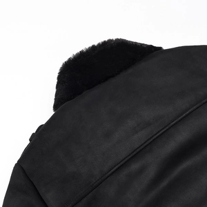 Detailaufnahme einer schwarzen Wildlederjacke mit üppigem Pelzkragen und feinen Nähten