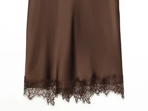 Detailansicht des dunkelbraunen Satin-Kleidsaums mit filigranem Wimpernspitzen-Besatz