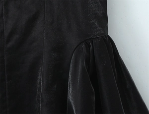 Dettaglio macro del tessuto dell'abito a pieghe nero con cuciture fini e trama lucida