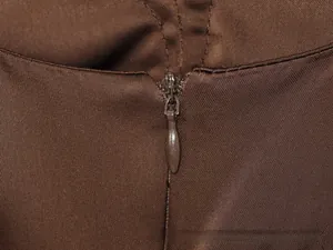 Detail eines unsichtbaren Reißverschlusses an einem braunen Kleid mit Köperbindung