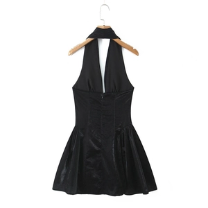 Dettaglio dell'abito con scollo all'americana e gonna a pieghe dal tessuto lucido