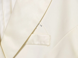 Detail of a creamy white satin blazer dress with sparkling rhinestone pocket embellishments