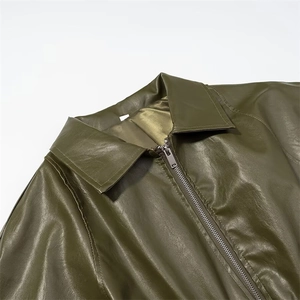 Détail du col d'une veste en similicuir vert olive et fermeture éclair métallique