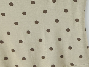 Gros plan sur le tissu en maille beige doux avec motif à pois marron classique