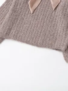 Detail of pink knit sweater featuring fuzzy mohair texture and satin ribbon bow neckline