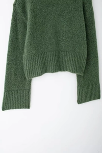 Dettaglio maglia verde scuro in misto mohair con polsini e orlo a costine spesse