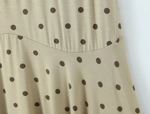 Gros plan du tissu beige à pois montrant les coutures et la texture douce