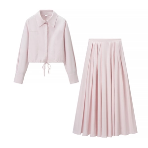 Détail de l'ensemble jupe deux pièces rose clair montrant la taille à cordon et le tissu plissé