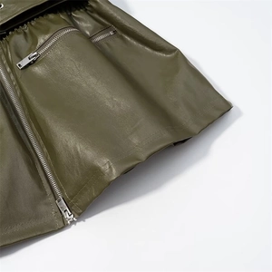 Vue détaillée de la texture du cuir vert olive et des finitions de fermeture éclair en métal