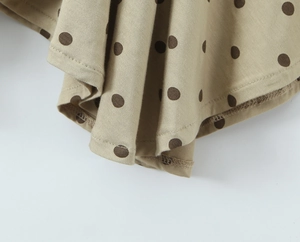 Gros plan sur le tissu à pois kaki avec détails de coutures soignées sur l'ourlet