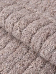 Macro shot of knit fabric texture with silver metallic yarn in taupe wave patterns