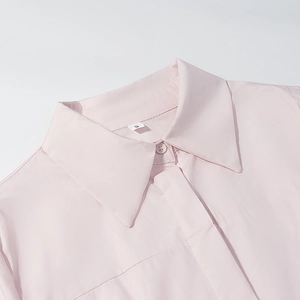 Gros plan du col d'une chemise rose clair avec coutures nettes et étiquette taille S