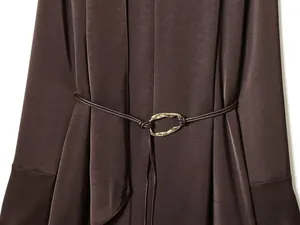 Detail of silk satin dress with elegant thin waist belt and gold geometric metal buckle