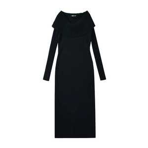 Detail of elegant black knitted dress featuring ruffled off-shoulder collar and long sleeves