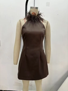Detail view of the brown halter neck dress featuring premium feather trim and satin finish