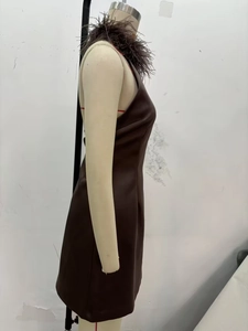 Detail shot of the faux leather dress featuring a textured feather collar and halter neck