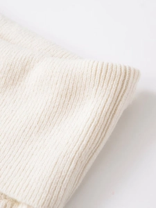 Close-up of ivory ribbed knit fabric texture with soft vertical fiber patterns
