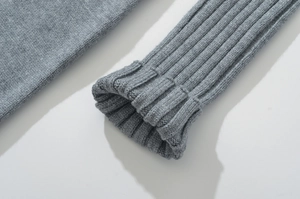 Detail of grey knitted dress sleeve with ribbed cuffs showing fine fabric texture