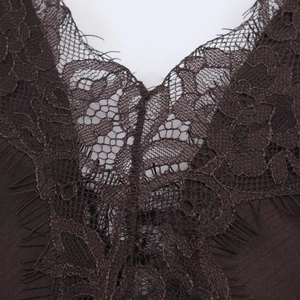 Close-up of deep brown lace V-neckline with eyelash trim on smooth satin dress fabric