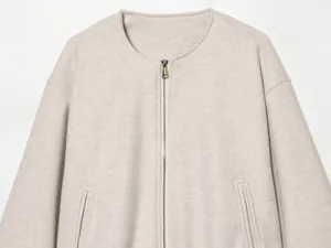 Gros plan sur la veste aviateur en laine beige avec col rond et zip métallique